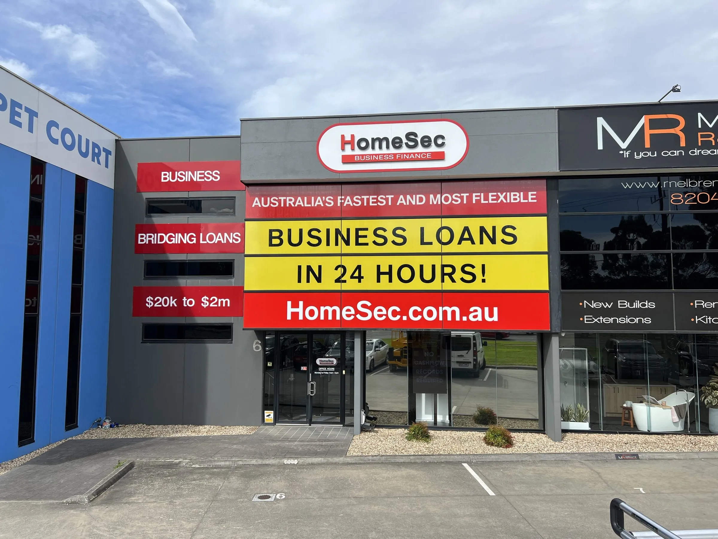 The HomeSec Business Finance head office in Knoxfield, Melbourne — a two-storey commercial building with the HomeSec Business Finance sign across the upper facade and the office entrance below